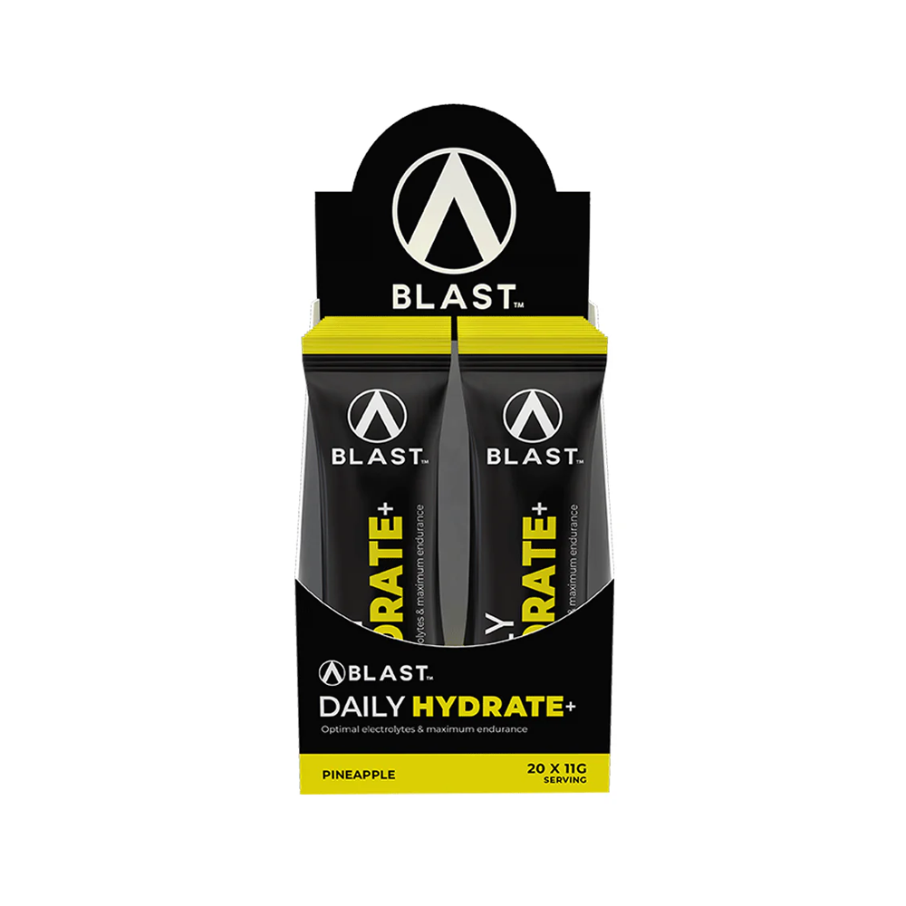 Display of Blast Daily Hydrate+ sachets in a carton with a black and yellow design on a white background.