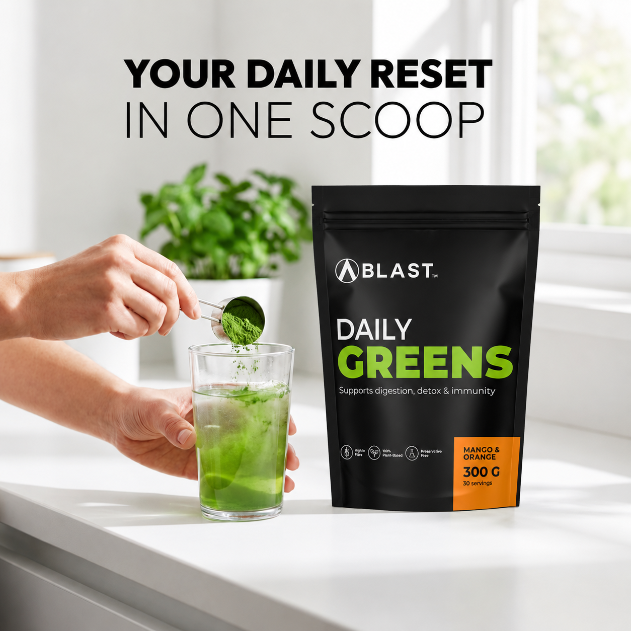 Person adding Blast Daily Greens powder to a glass with a BLAST Daily Greens package on a white surface.