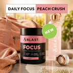 Blast Focus supplement container with peach crush flavor on a marble surface with a pink bag and water bottle in the background.