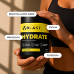 Person holding a 'BLAST Hydrate' supplement container with labeled ingredients on a neutral background