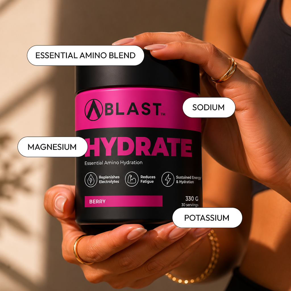 Person holding a 'A Blast Hydrate' supplement bottle with labeled ingredients on a neutral background