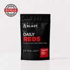 A black stand-up pouch of BLAST Daily Reds dietary supplement, strawberry & kiwi flavor, 300g. The packaging features white and red text, and a red 'Bestseller' badge is shown in the top-left corner.